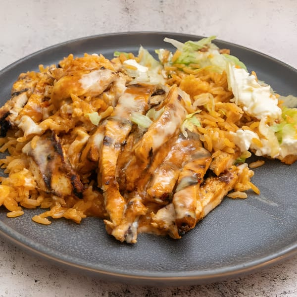 El Que Pasa's grilled chicken with melted cheese, rice, and a side of lettuce and sour cream.