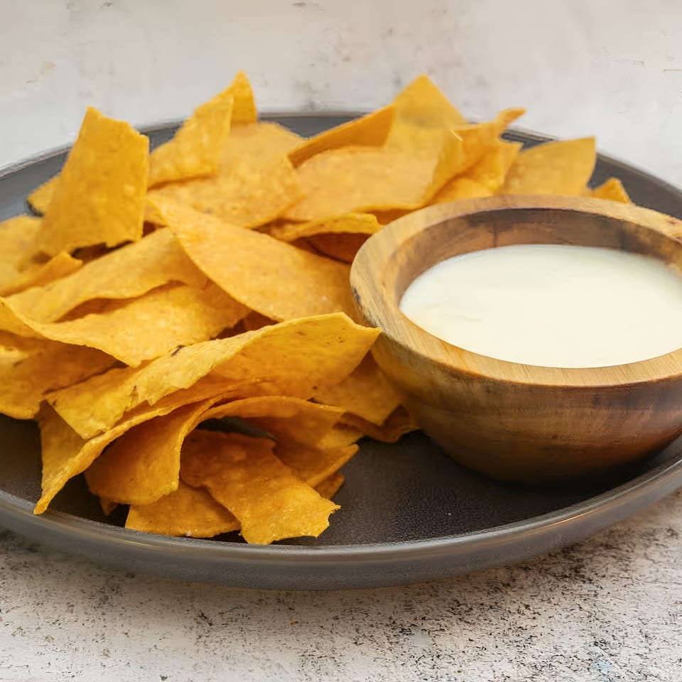 El Que Pasa's crispy tortilla chips served with a side of creamy white queso dip.